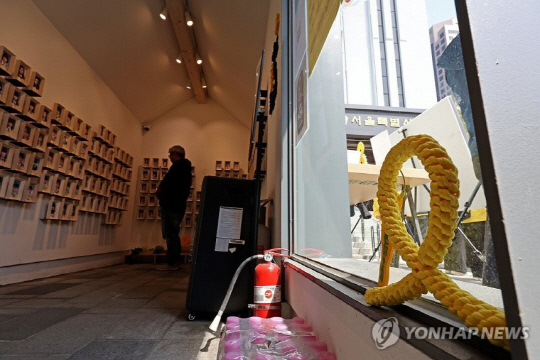 세월호 참사 11주기를 하루 앞둔 15일 서울시의회 앞 설치된 세월호 기억공간을 한 시민이 둘러보고 있다. 연합뉴스